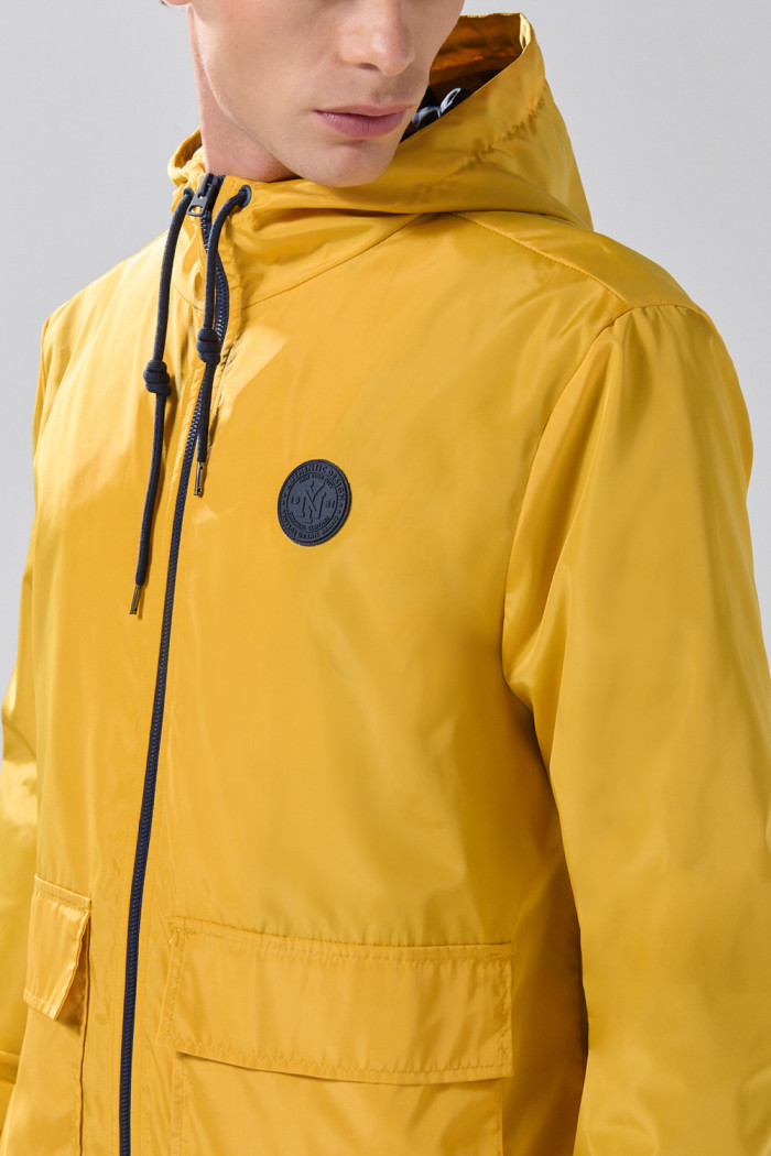 Chaqueta unicolor liviana con doble bolsillo y capota